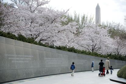 Una familia camina junto a un muro que muestra frases de Martin Luther King, en Washington.