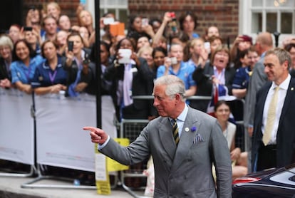 El príncipe Carlos de Inglaterra saluda a los fotógrafos a su llegada al hospital, donde él y su mujer, Camila, visitaron al primogénito de los duques de Cambridge.