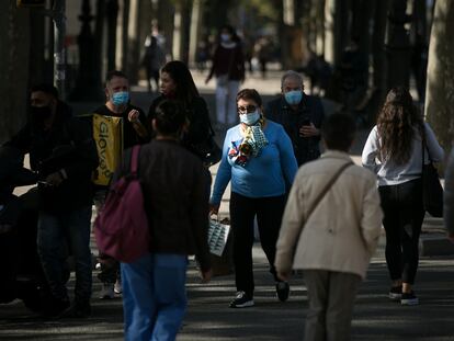 Ciudadanos, confundidos, pasean con mascarillas por la Diagonal de Barcelona.