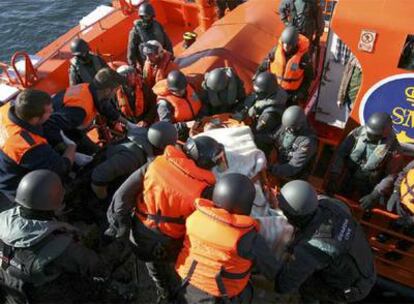 Agentes especiales de la Guardia Civil en el momento de desembarcar en el puerto de Fisterra al presunto asesino, inmovilizado en una camilla.