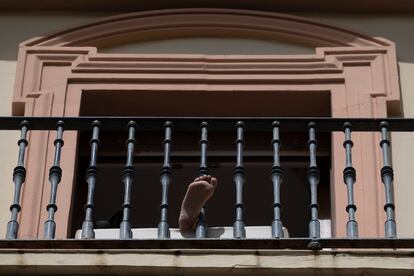 Una vecina toma el sol en el balcón de su piso, ayer en Sevilla.