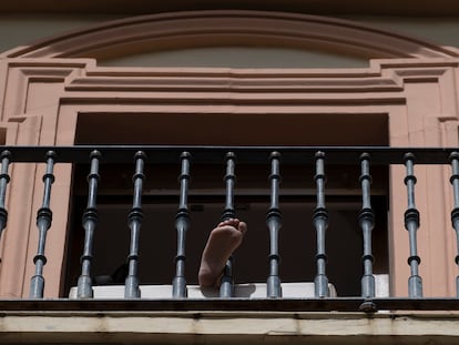 Una vecina toma el sol en el balcón de su piso, ayer en Sevilla.