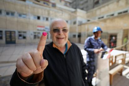 Un hombre muestra su dedo manchado de tinta después de votar en Alejandría, el 26 de marzo.