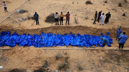 Un grupo de operarios entierra decenas de cadáveres en una fosa común en el cementerio de Jan Yunis, en el sur de Gaza, el 22 de noviembre.