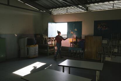La portera de la Escuela Canaima abre las ventanas de un salón de preescolar en Caracas, Venezuela. Las aulas están vacías desde marzo de este año, cuando se suspendieron las clases presenciales a nivel nacional.