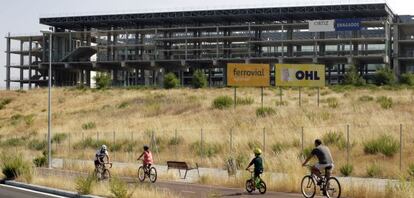 Cyclists make their way past the unfinished aquatic center, which was set to be a key venue had Madrid's Olympic bid prospered.