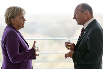 La canciller alemana, Angela Merkel, y el presidente rumano, Traian Basescu, conversan durante una reunión en Berlín.