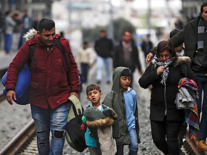 Refugiados caminan por las vía del tren durante una protesta, este viernes, en la estación central de Atenas (Grecia).