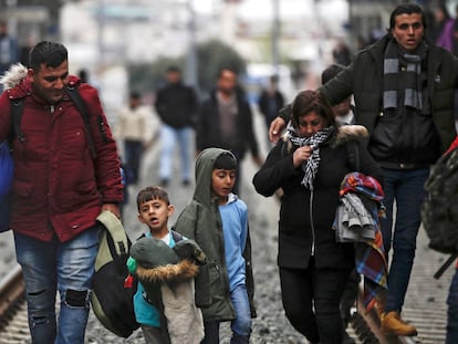 Refugiados caminan por las vía del tren durante una protesta, este viernes, en la estación central de Atenas (Grecia).