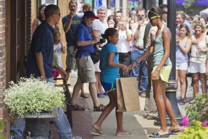 Obama y sus hijas Sasha y Malia a la salida de la librería.