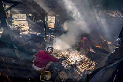 Varias personas cocinan pescado ahumado en Surabaya, (Indonesia).