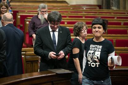 Carles Puigdemont, presidente de la Generalitat, consulta el móvil tras una sesión en el Parlament de Cataluña.