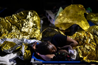 Una mujer y un niño duermen en el exterior del centro de acogida de inmigrantes de Lampedusa, Sicilia, a primera hora del jueves 14 de septiembre de 2023.