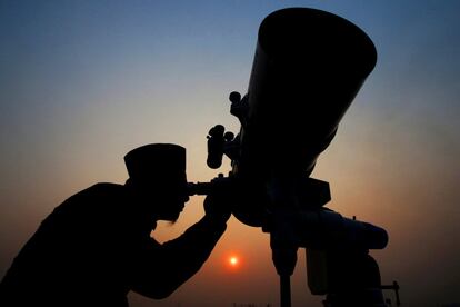 Un hombre mira a través de un telescopio para el avistamiento de la luna nueva que marca el inicio del mes de ayuno del Ramadán, en un internado religioso en Yakarta, Indonesia.