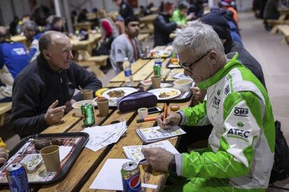 El copiloto italiano Maurizio Dominella revisa en el comedor el libro de ruta para la próxima etapa.