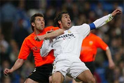 El valencianista Marchena forcejea con Raúl en la jugada que decidió el empate final.
