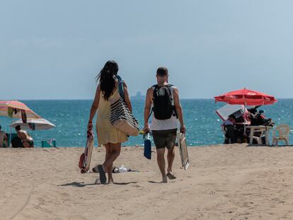Dos personas se dirigen a la playa de El Saler, en Valencia, el 11 de agosto de 2023.