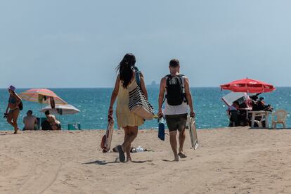 Dos personas se dirigen a la playa de El Saler, en Valencia, el 11 de agosto de 2023.