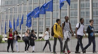 Un grupo de jóvenes pasan junto a la sede de la Comisión Europea, en Bruselas.