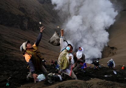 Indonesios recogen monedas lanzadas por la tribu Tengger, muy cerca del cráter del Monte Bromo, durante la celebración del 'Yadnya Kasada'. La población Tengger asciende a 90.000 habitantes divididos en una treintena de pueblos situados en el Parque Nacional BromoTengger Semeru, en la provincia de Probolinggo, Indonesia.