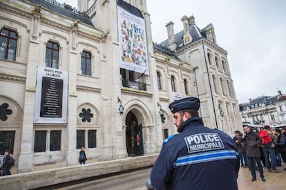 Un policia vigila l'Ajuntament d'Angulema, que exhibeix un cartell d'homenatge a 'Charlie Hebdo'.