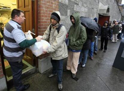 Inmigrantes hacen cola ante un centro de ayuda gestionado por monjes capuchinos en Dublin.