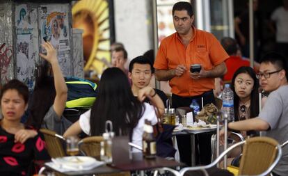 Un camarero cobra a un grupo de turistas en una terraza del centro de Madrid.