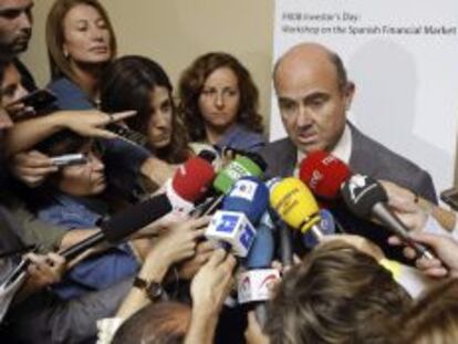 El ministro de Econom&iacute;a, Luis de Guindos, atiende a los medios tras clausurar una jornada de trabajo organizada por el Fondo de Reestructuraci&oacute;n Ordenada Bancaria (FROB).