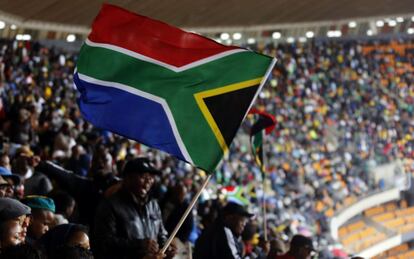 Un hombre ondea una bandera sudafricana.