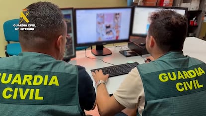 Dos agentes de la Guardia Civil analizan una página web que muestra imágenes de desnudos sospechosos de haberse creado con IA, en una fotografía facilitada por el instituto armado a raíz de la Operación Edunia.