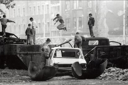 Niños de Sarajevo saltan entre los coches destruidos durante la guerra, en octubre de 1993.