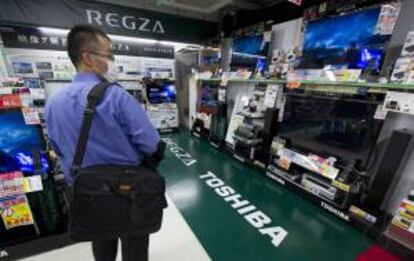 Un consumidor japonés observa varias televisores Toshiba en una tienda de electrónica. EFE/Archivo