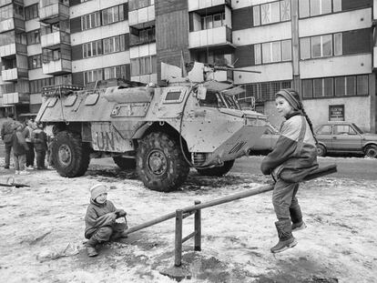 Dos niños juegan durante el cerco de Sarajevo ante un blindado de Naciones Unidas.