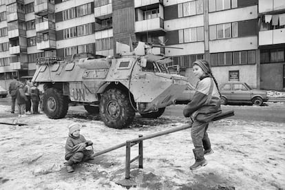 Dos niños juegan durante el cerco de Sarajevo ante un blindado de Naciones Unidas, imagen incluida en el documental de Movistar ‘Gervasio Sánchez. Álbum de posguerra’.