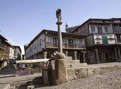 Plaza mayor del pueblo salmantino de La Alberca, donde destacan la piedra de granito, los soportales y la madera de las balconadas llenas de flores.
