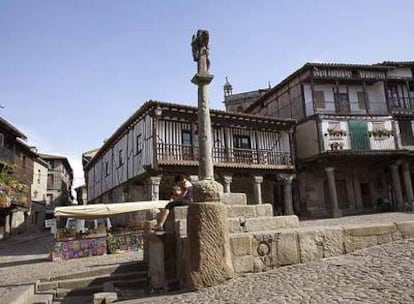 Plaza mayor del pueblo salmantino de La Alberca, donde destacan la piedra de granito, los soportales y la madera de las balconadas llenas de flores.