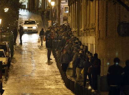 Decenas de personas esperan para cenar en la Real Hermandad del Refugio y Piedad de Madrid, en la calle de la Corredera Baja de San Pablo (Centro).