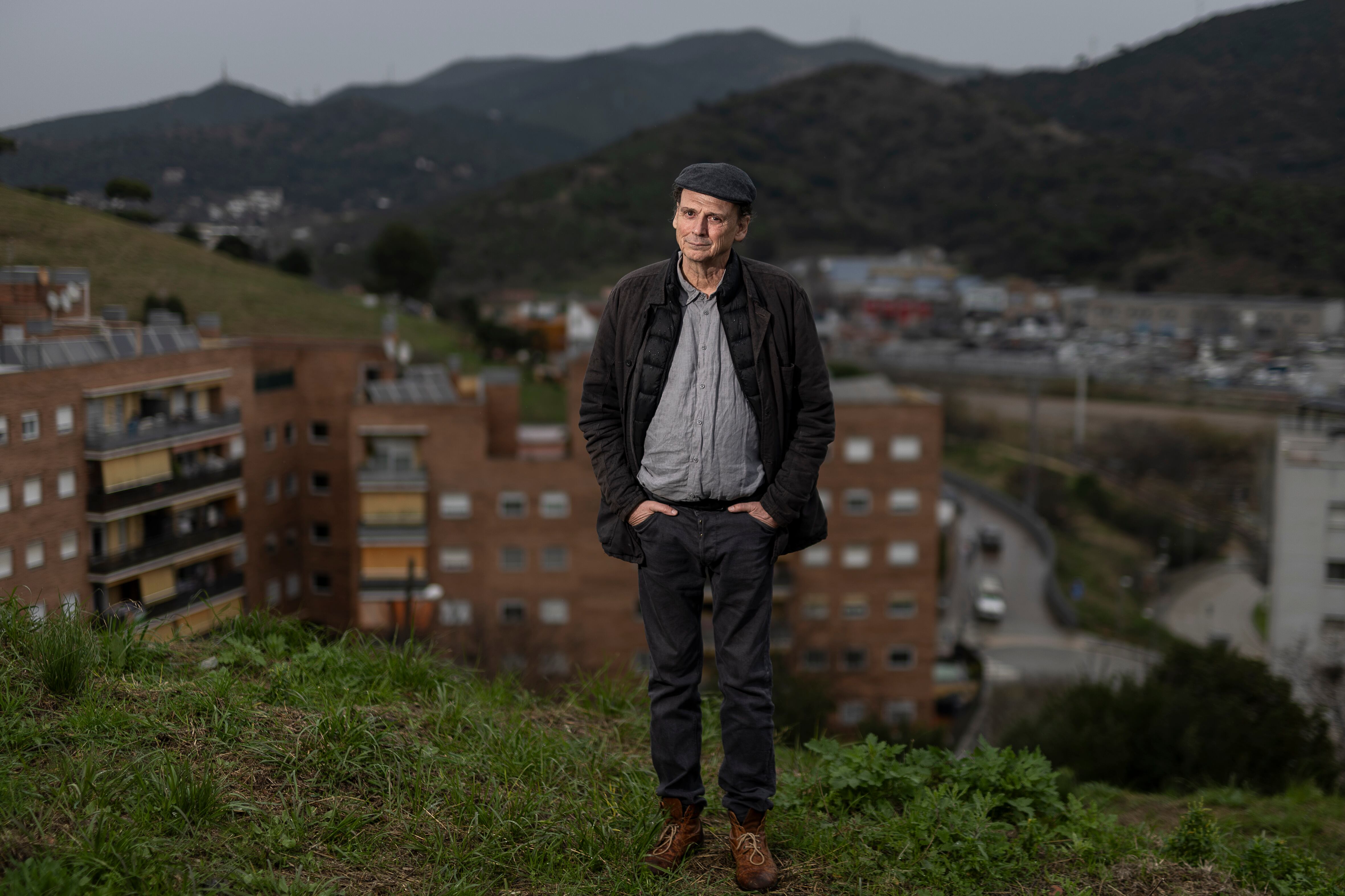 José Luis Guerin posa de espaldas a las viviendas de protección oficial de Vallbona, edificios que aparecen en 'Historias del buen valle'.