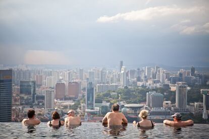 Huéspedes del hotel Marina Bay Sands contemplan la ciudad desde la piscina infinita situada en la azotea del Sky Park.