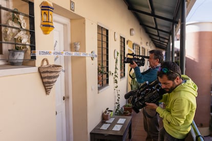 Los equipos de televisión graban la entrada de la casa donde se encontró el cadáver de la mujer, precintada por la Policía Nacional.