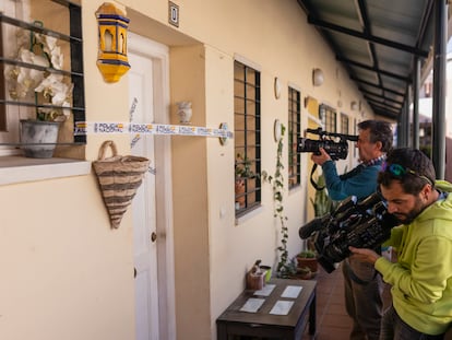 Los equipos de televisión graban la entrada de la casa donde se encontró el cadáver de la mujer, precintada por la Policía Nacional.