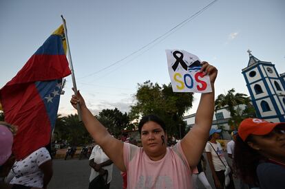 Una mujer sostiene la bandera de Venezuela en una protesta por la muerte en un naufragio de migrantes venezolanos, el 17 de diciembre.