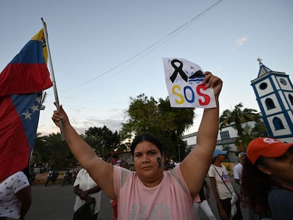Una mujer sostiene la bandera de Venezuela en una protesta por la muerte en un naufragio de migrantes venezolanos, el 17 de diciembre.