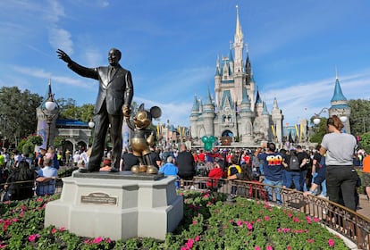 In this Jan. 9, 2019 photo, guests watch a show near a statue of Walt Disney and Micky Mouse in front of the Cinderella Castle at the Magic Kingdom at Walt Disney World in Lake Buena Vista, Fla.