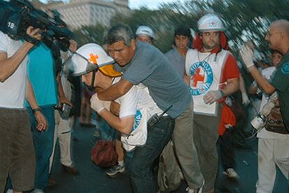 Uno de los 23 heridos por la explosión en Plaza de Mayo es retirado por miembros del servicio de emergencias.