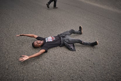 Un joven con una camiseta en la que se puede leer “protestar no es un crimen” se tumba en mitad de la carretera para bloquear el tráfico frente a la morgue de Nairobi, el pasado 9 de junio.