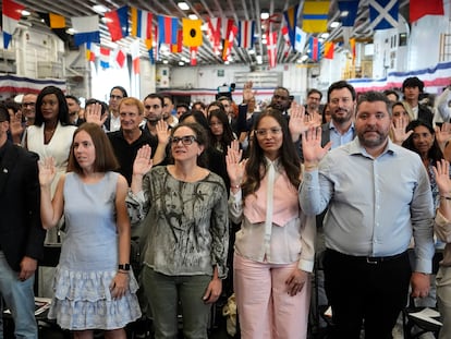 Personas juran durante su ceremonia de naturalización abordo del USS Bataan en Miami (Florida), el 7 de mayo.