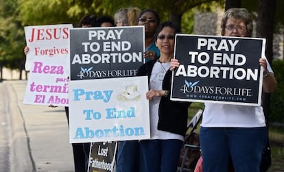 Manifestantes en contra del aborto sostienen carteles pro vida.