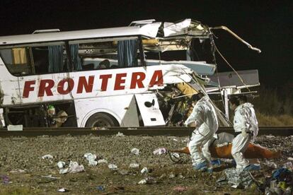 Forenses cargan los cuerpos de las víctimas del accidente.