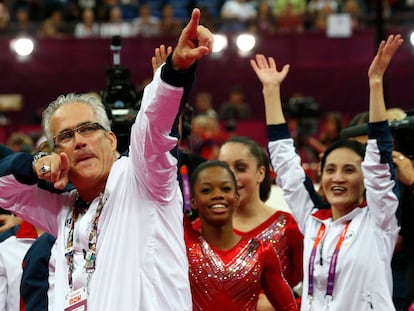 El entrenador del equipo femenino de gimnasia de Estados Unidos, John Geddert, celebra con el equipo la medalla de oro en los Juegos Olímpicos de Londres 2012.